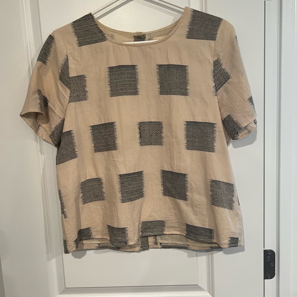 Bohme size medium back button up blouse with black square stitched details.